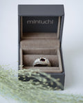 Silver ring in a 'mintuchi' box on a white background