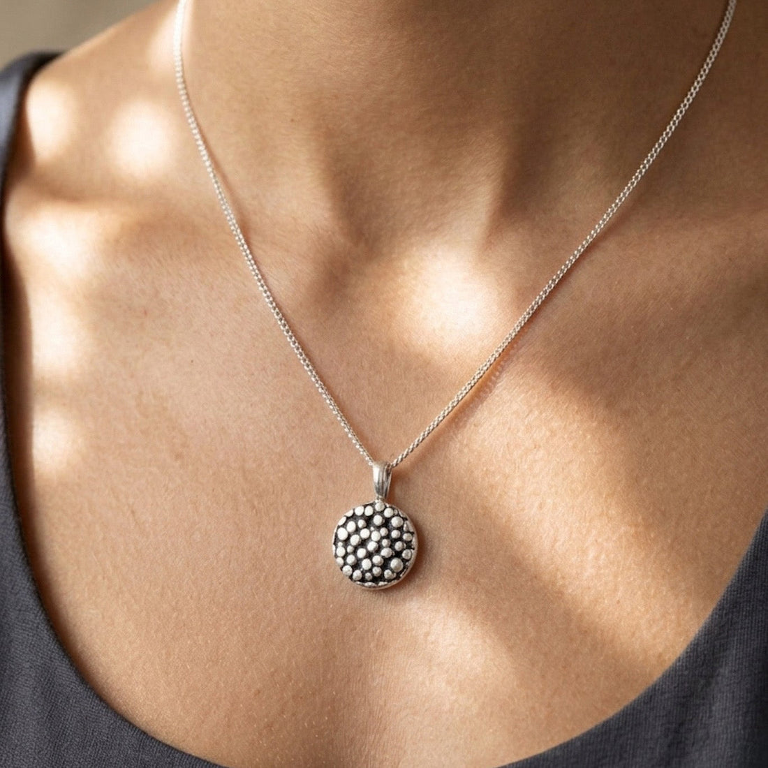 Necklace with a decorative pendant worn by a person