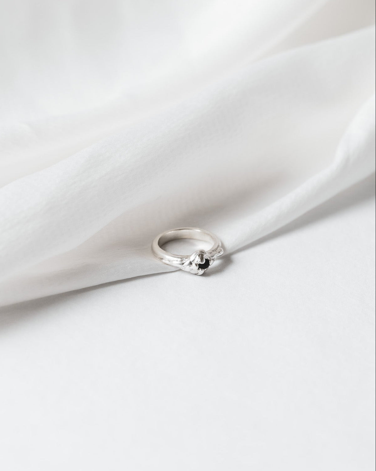 Silver ring on a white fabric background