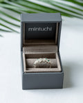Ethical lab-grown emerald and moissanite silver ring presented in a sustainable jewelry gift box.