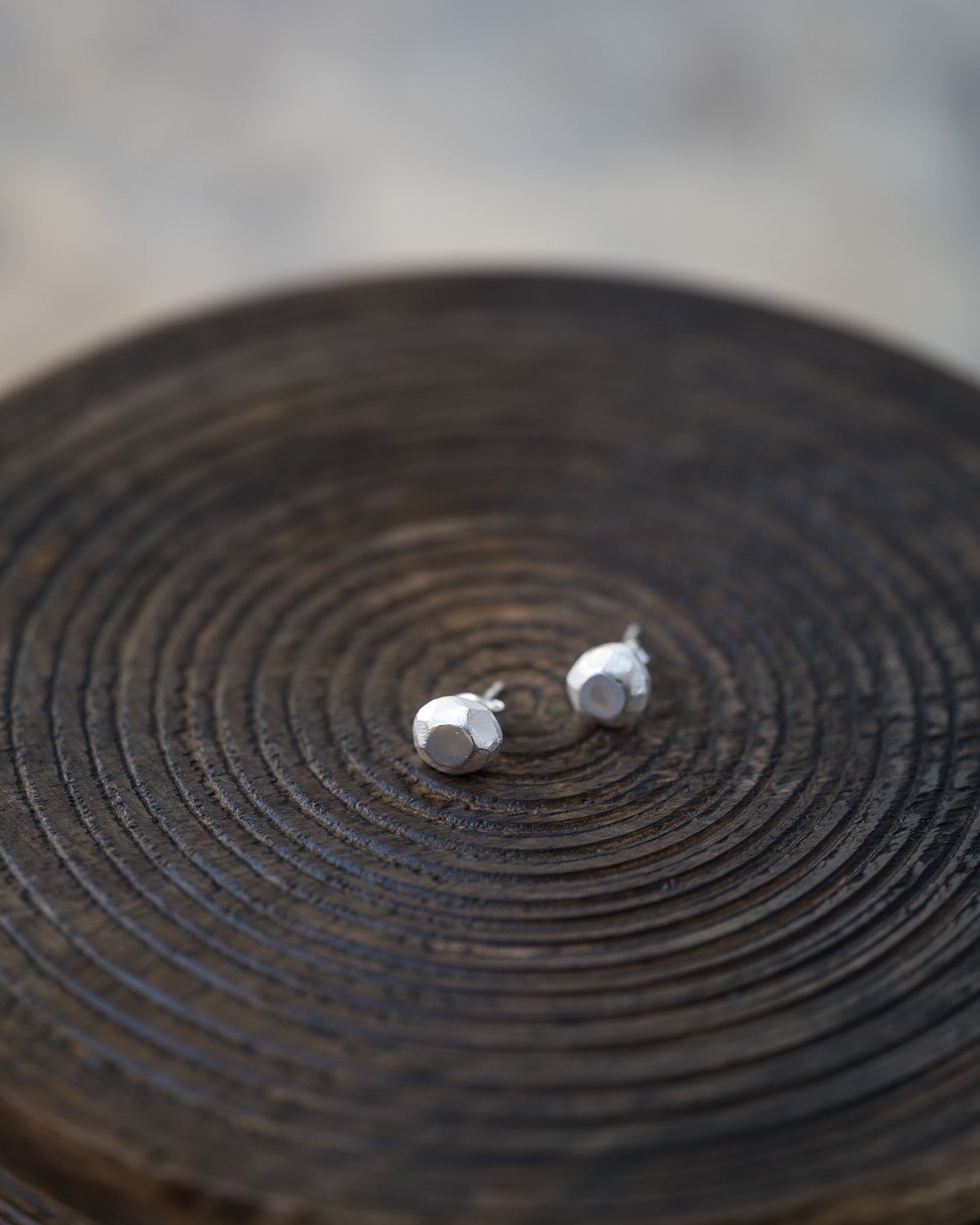 Silver stud earrings on a wooden surface