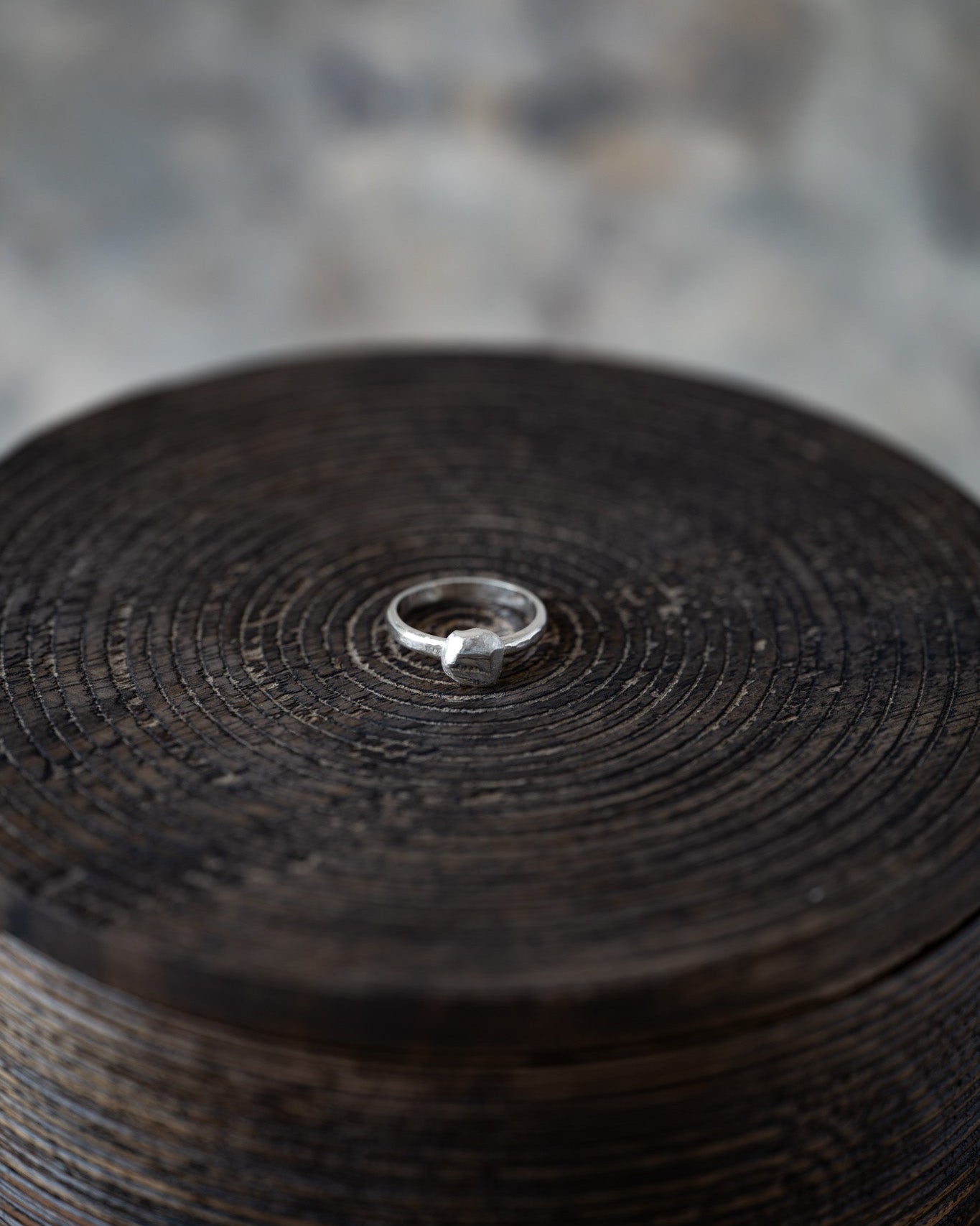 Close-up of a wooden reel with a metal ring on a textured surface