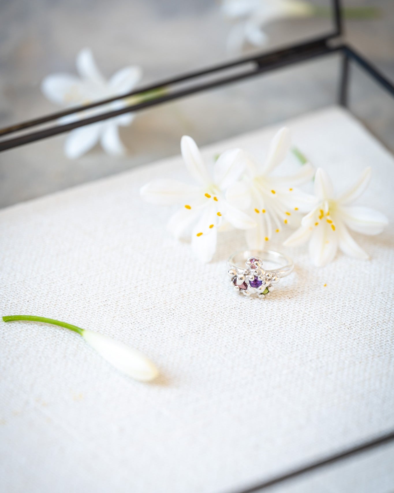 Floral earring on a white cushion with a mirror background