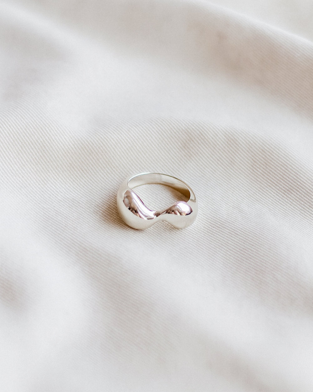 Silver ring on a light fabric background